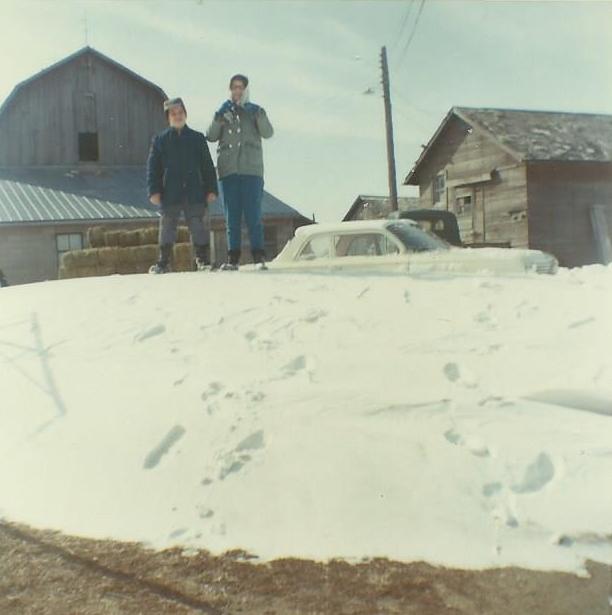 John Munsell and Marilyn Munsell on a snowdrift in the yard